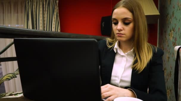La chica en el café sentada detrás de su propio portátil — Vídeos de Stock