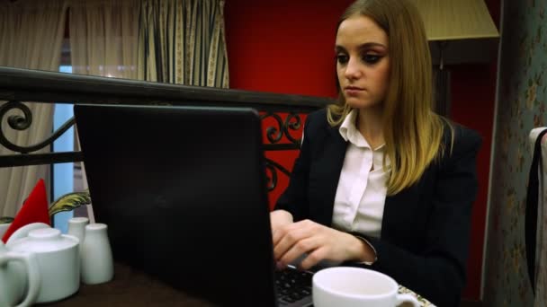 La empresaria se sienta en el sofá y escribe el texto en el portátil — Vídeo de stock