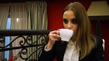 Düşünceli bir bardaktan çay içme iş elbiseli kız