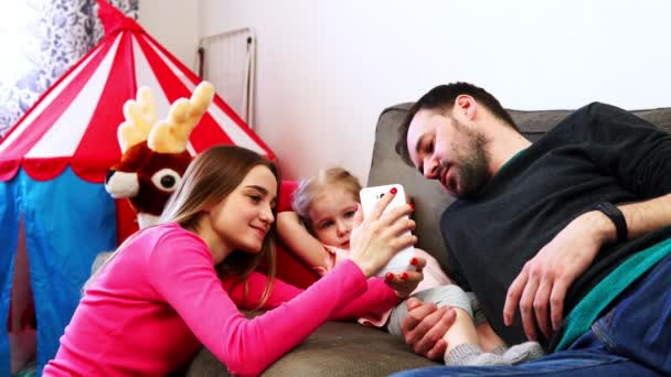 Familjen mor far och dotter tittar på smartphone — Stockvideo
