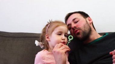 Mutlu baba ve küçük Prenses kız kabarcıklar üfleme.