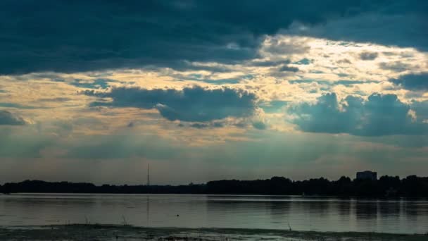 Dramatická modrá obloha s paprsky rozbíhajícího se slunce nad řekou — Stock video