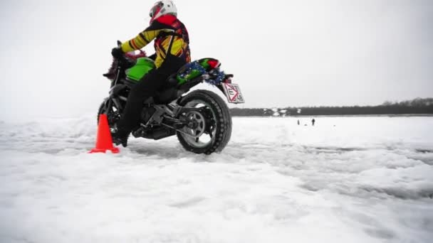 Man rides on motorcycle on snowed and frozen road on professional track. — Stock Video