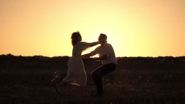 Pareja romántica girando abrazos en el fondo de la puesta del sol — Vídeo de stock