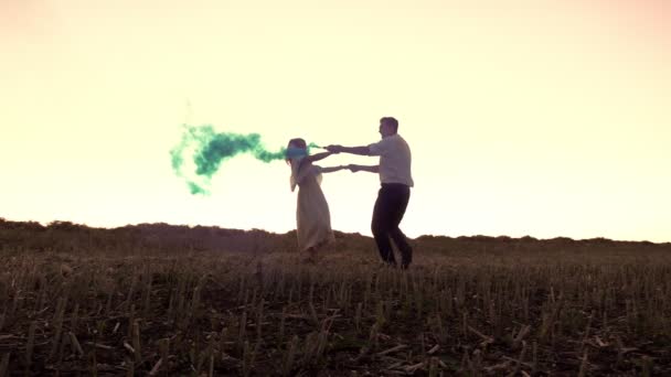 Man and woman spin around holding smoke flares — Stock Video