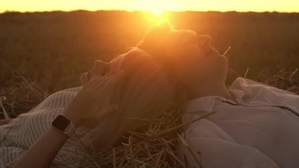 Loving man and woman are laying on the grass head to head — Stock Video