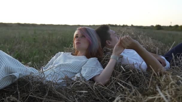 Amando l'uomo e la donna che posano su un fieno tenendosi per mano — Video Stock