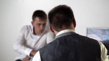 Bir adam başka bir adama gizli bir not verir.