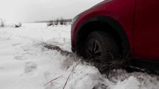 Машина застрягла в снігу і викопала отвір з колесом, в снігопаді — стокове відео