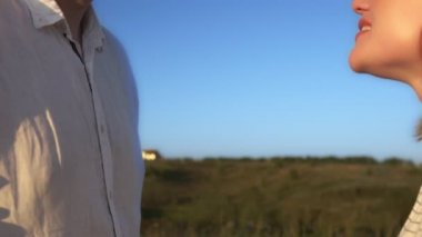 Kadın ve erkek el ele tutuşup öpüşüyorlar.