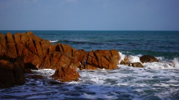 Ola golpea contra grandes rocas en el océano con agua clara — Vídeo de stock