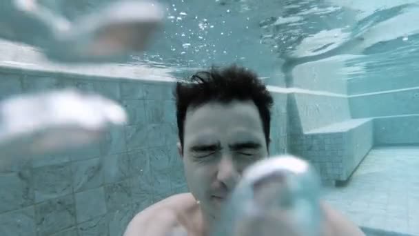 Mladý muž se potápí ve střešním bazénu a usmívá se — Stock video