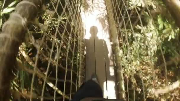 L'homme traverse le pont des singes suspendu au-dessus de la jungle — Video