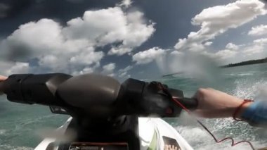 Su motoruna binen adam okyanusta dalgalar kırıyor.