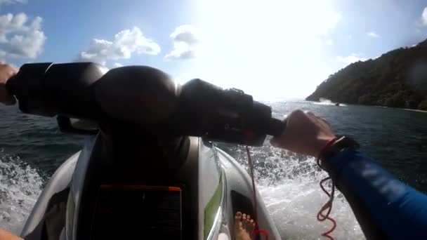 Homem dirige água scooter quebrando ondas perto da ilha — Vídeo de Stock