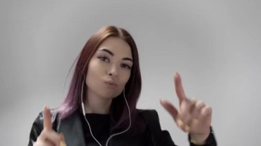 Genç ve çekici bir kadın kulaklıklarıyla müzik dinlemekten ve dans etmekten hoşlanıyor.