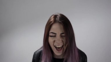 Çığlık atan ve ellerini saçlarına gömen kızın portresi. Acı hissediyordu.