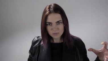 Renkli saçlı genç bir kadın nefret ve öfkeyle el ele tutuşup bağırıyor.