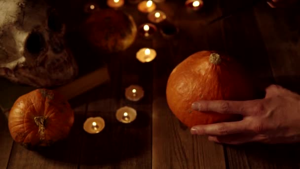 Talla Jack de linterna fuera de una vista superior de calabaza en el fondo de un cráneo y velas — Vídeos de Stock