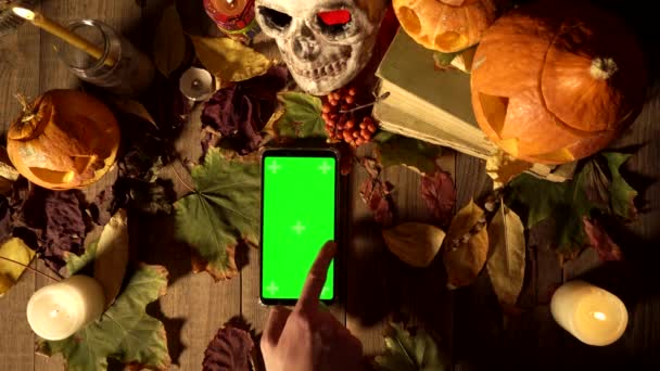 Sammansättning av en Halloween och smartphone med en grön skärm med gester. — Stockvideo