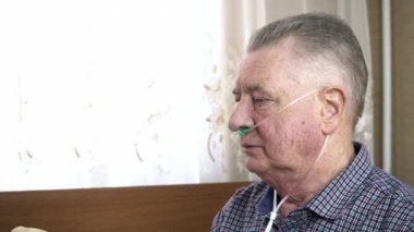 Tıbbi oksijen kanülü olan adam derin bir nefes alır.