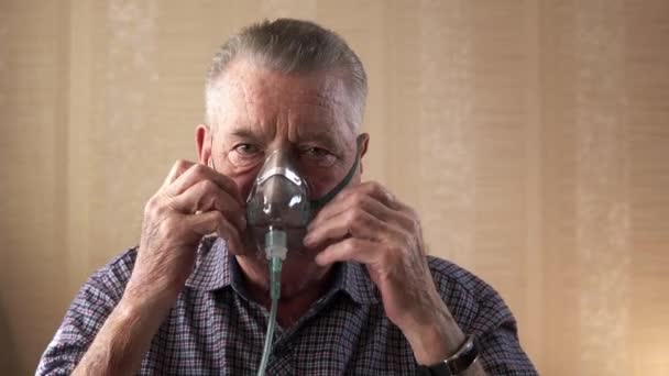 De oude man zet het ademhalingsmasker op en haalt weinig diep adem. — Stockvideo