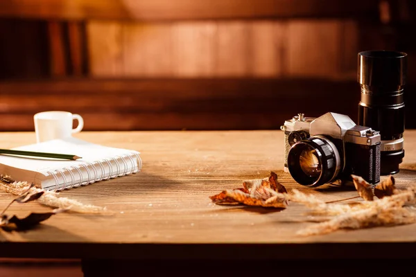 Il blocco note, penna e vecchia macchina fotografica Immagine Stock