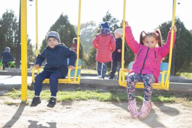 kız ve oğlan bir salıncak üzerinde