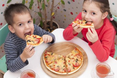 Çocuklar pizza yer.