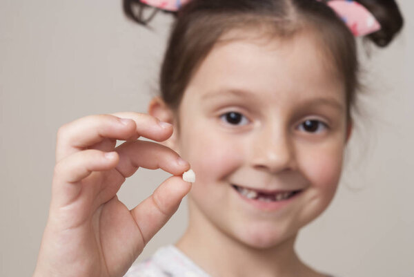 little girl and a milk tooth