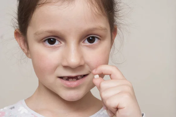 Little girl and a milk tooth — Stock Photo, Image