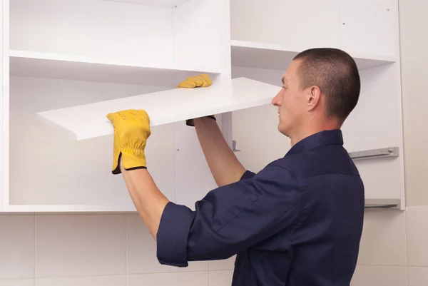 Trabajador ensambla muebles en la cocina — Foto de Stock