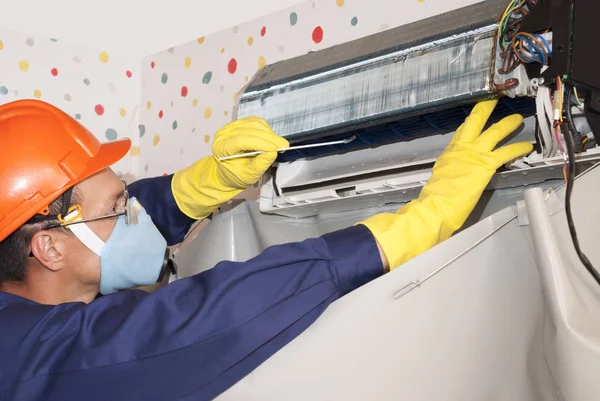 professional worker cleans the indoor unit of the air conditioner