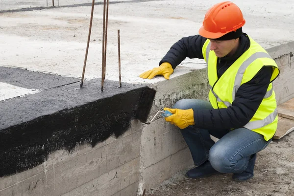 Pracownik Budowlany Wykonuje Hydroizolację Bitumiczną Fundamentów Placu Budowy — Zdjęcie stockowe