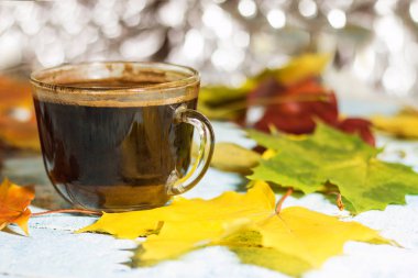 Bir bardak sabah kahvesi sonbahar bir masada bırakır