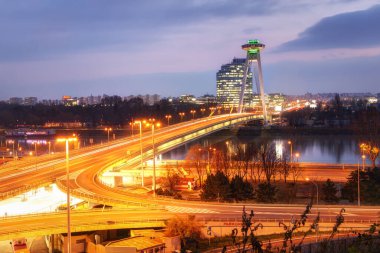 Bratislava, Slovakya: 25 Kasım 2019 - Bratislava 'daki Tuna Nehri üzerindeki köprü, SNP köprüsü. Köprüde akşam manzarası ve alacakaranlıkta UFO gözlem güvertesi