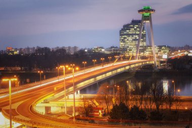 Bratislava, Slovakya: 25 Kasım 2019 - Bratislava 'daki Tuna Nehri üzerindeki köprü, SNP köprüsü. Köprüde akşam manzarası ve alacakaranlıkta UFO gözlem güvertesi