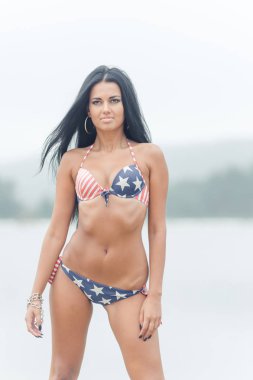 Genç güzel siyah saçlı kadın su sahilde poz