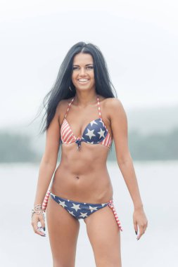 Genç güzel siyah saçlı kadın su sahilde poz