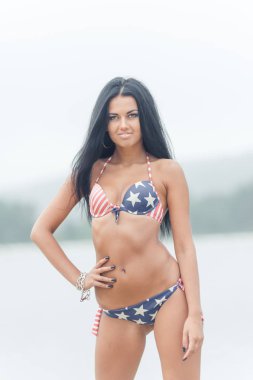 Genç güzel siyah saçlı kadın su sahilde poz