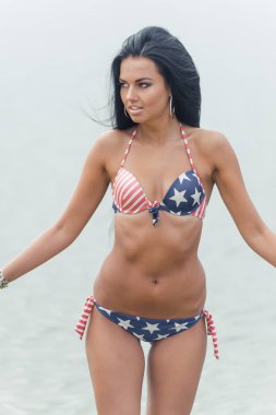 Kız ile Amerikan bayrağı sahilde