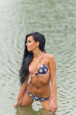 Kız ile Amerikan bayrağı sahilde