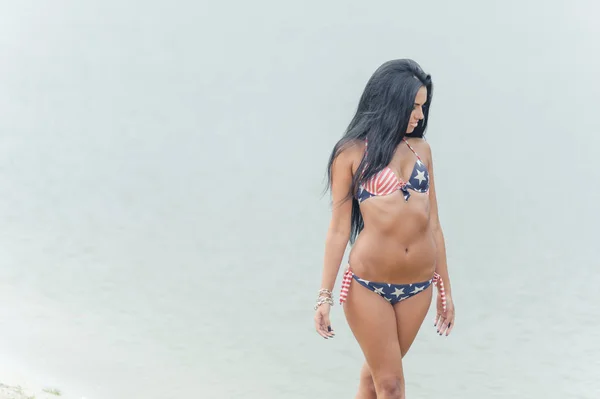 Joven hermosa mujer de pelo negro posando en la playa en el agua —  Fotos de Stock
