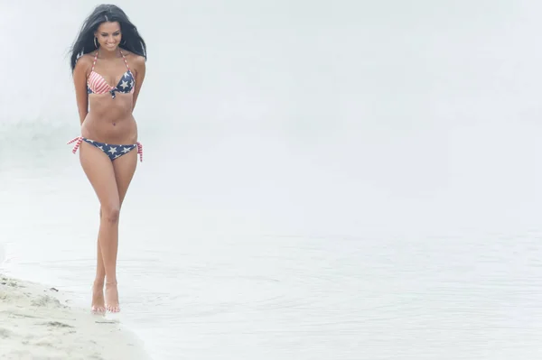 年轻美丽的黑头发女人在水的海滩上摆姿势 — 图库照片