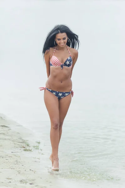 Joven hermosa mujer de pelo negro posando en la playa en el agua —  Fotos de Stock