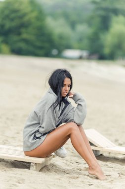 güzel kız plaj şezlong üzerinde oturur