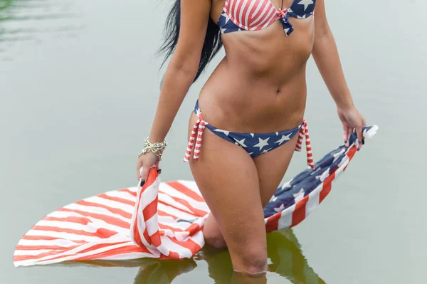 Девушка на пляже с американским флагом — стоковое фото