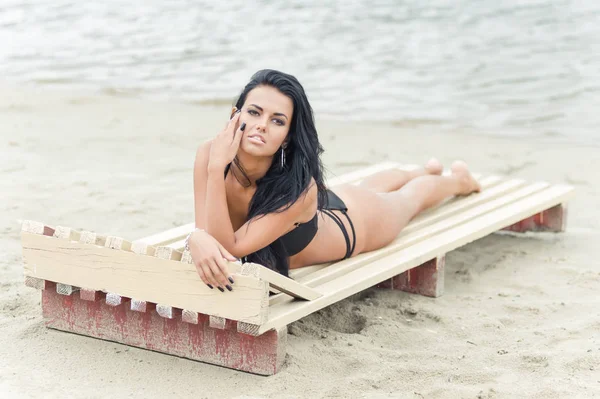 Schönes Mädchen posiert und lacht am Strand — Stockfoto