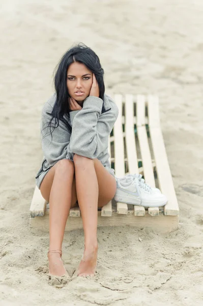 Hermosa chica morena posando en la playa en un traje de baño negro —  Fotos de Stock