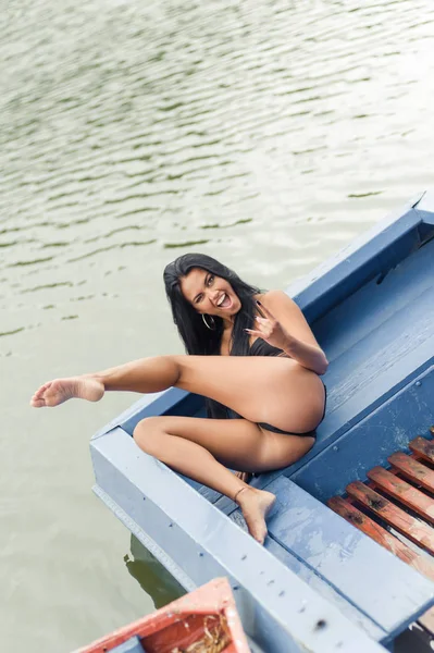 Menina de cabelos escuros bonita posando na praia em um maiô preto — Fotografia de Stock